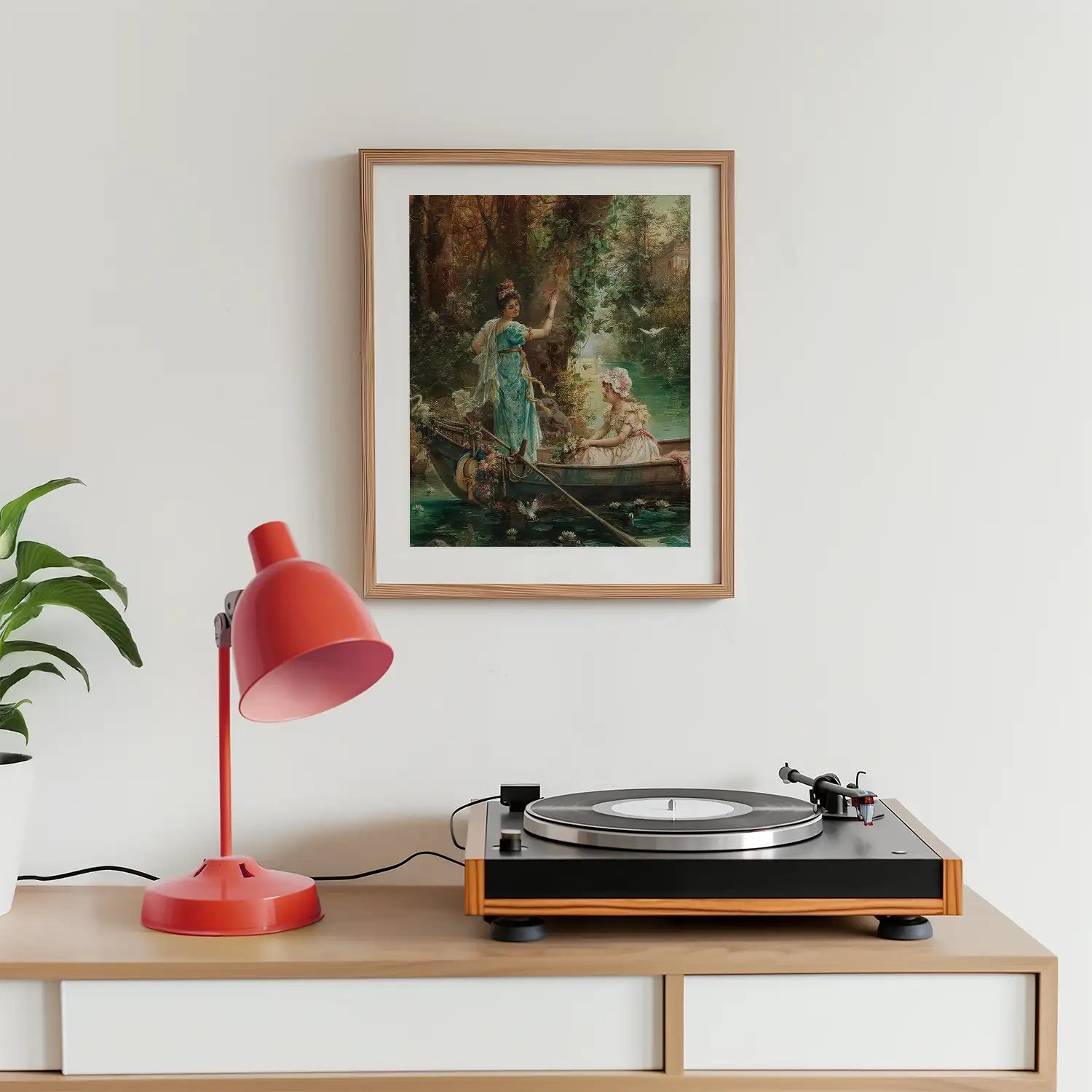 Framed vintage painting of a woman and a child in a boat, displayed on a wall above a wooden table with a red lamp and a record player.