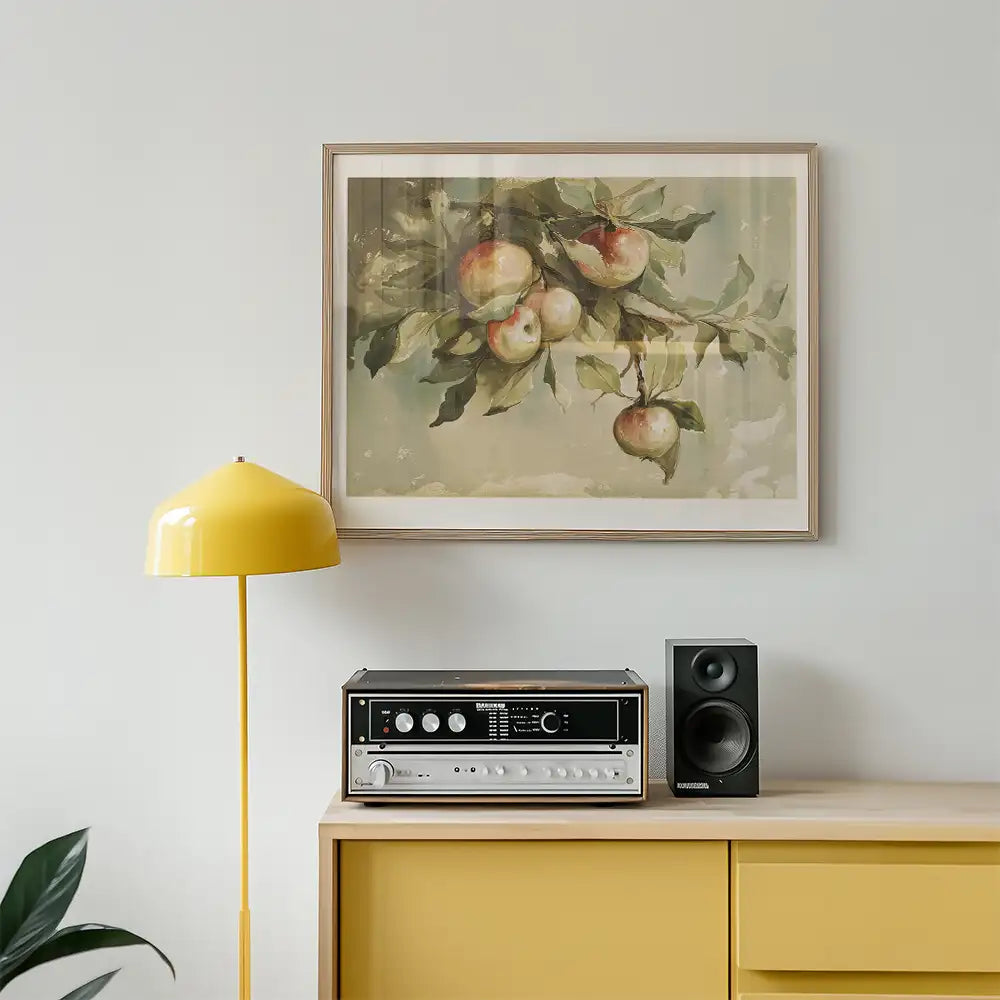 Painting of apples on a branch in a framed artwork above a yellow lamp and a vintage stereo on a wooden cabinet.