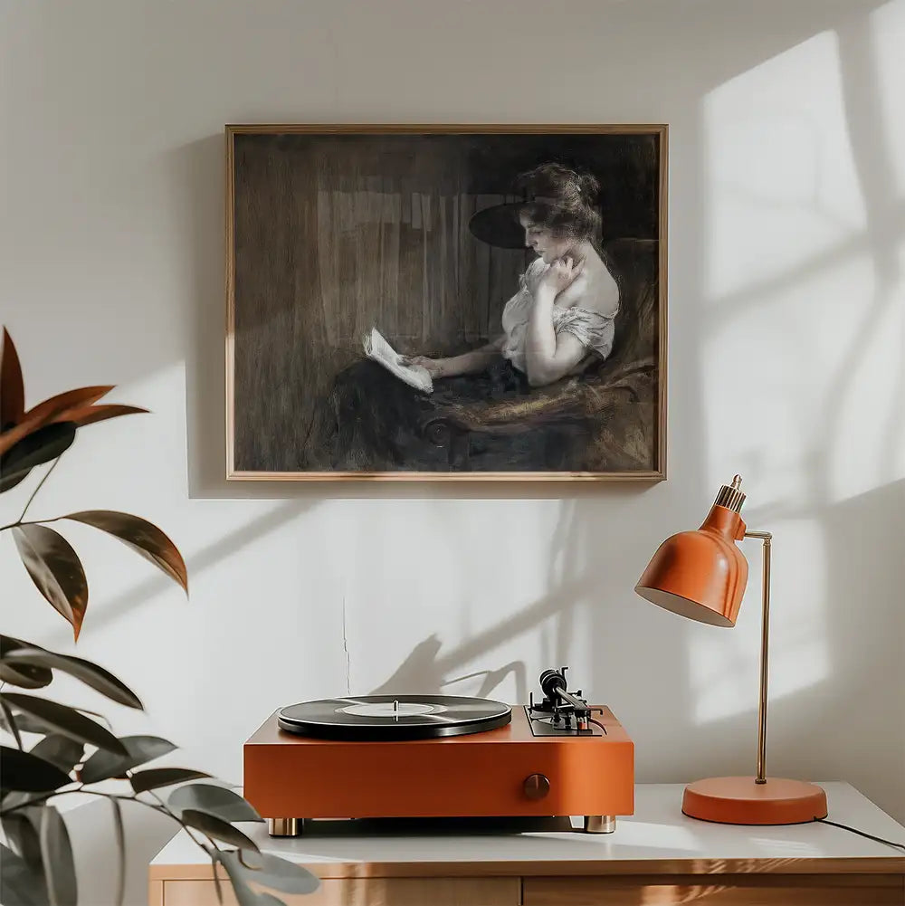 Framed painting of a woman reading, displayed above a vintage record player and orange lamp in a cozy interior setting.