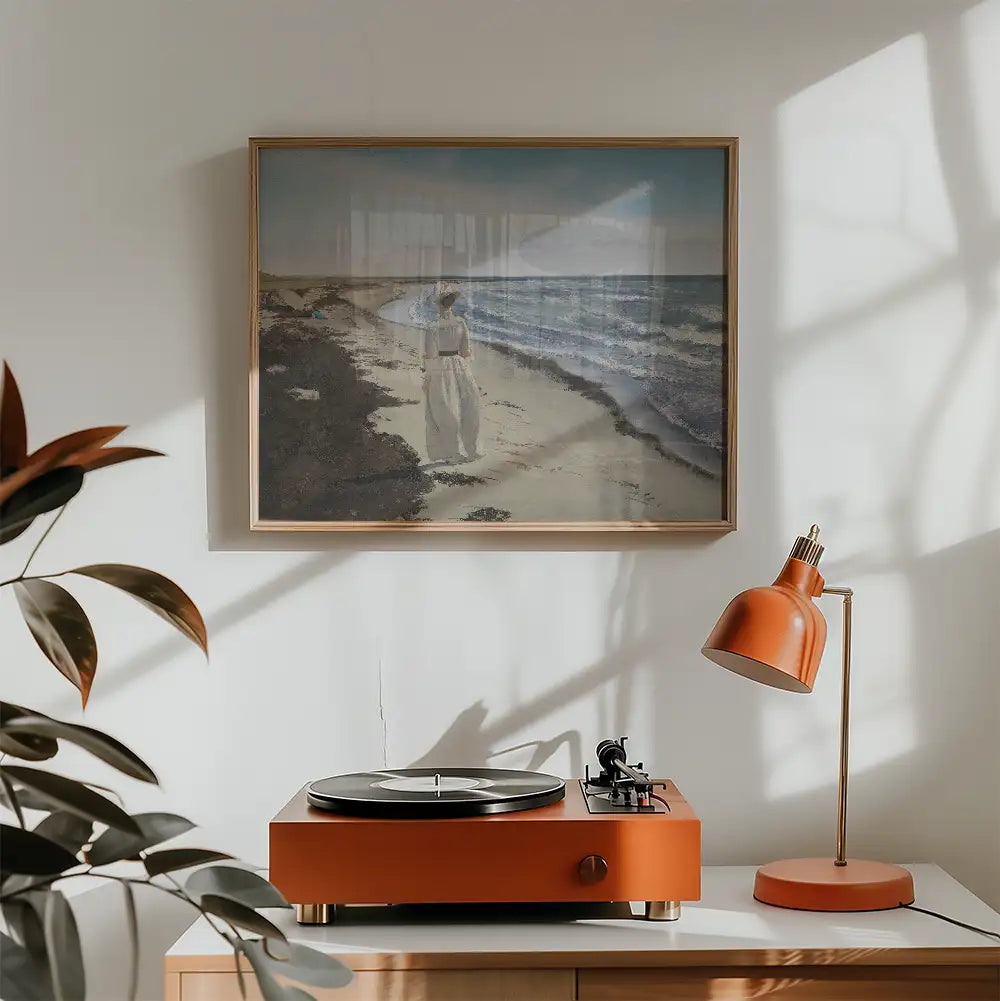 Painting of a woman walking along a beach, framed and hung above an orange turntable and lamp in a stylish interior setting.