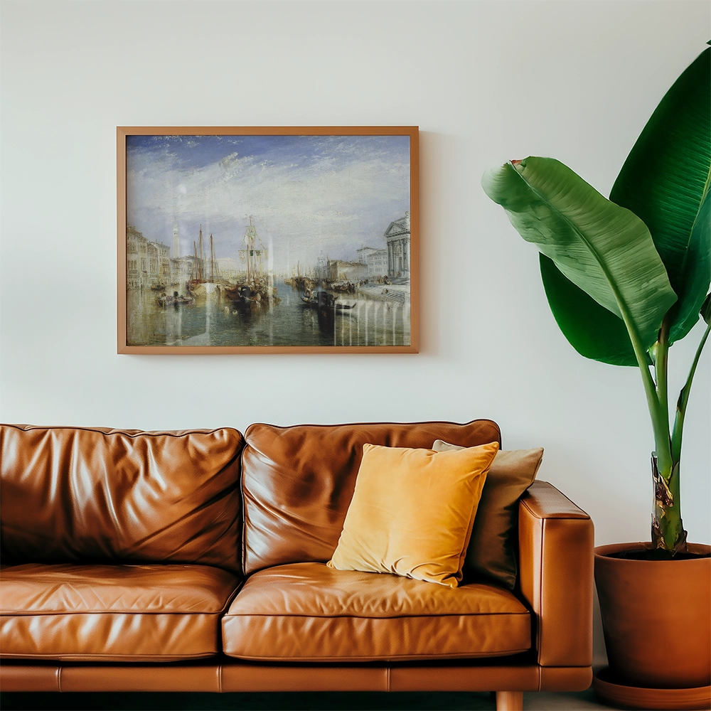 Framed painting of a serene waterfront scene hanging above a modern brown leather sofa with a yellow cushion and a large green plant in a pot.