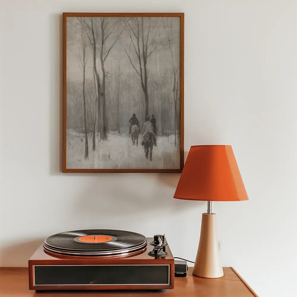 Painting of two horsemen in a snowy forest, framed and displayed above a vintage record player and an orange table lamp.
