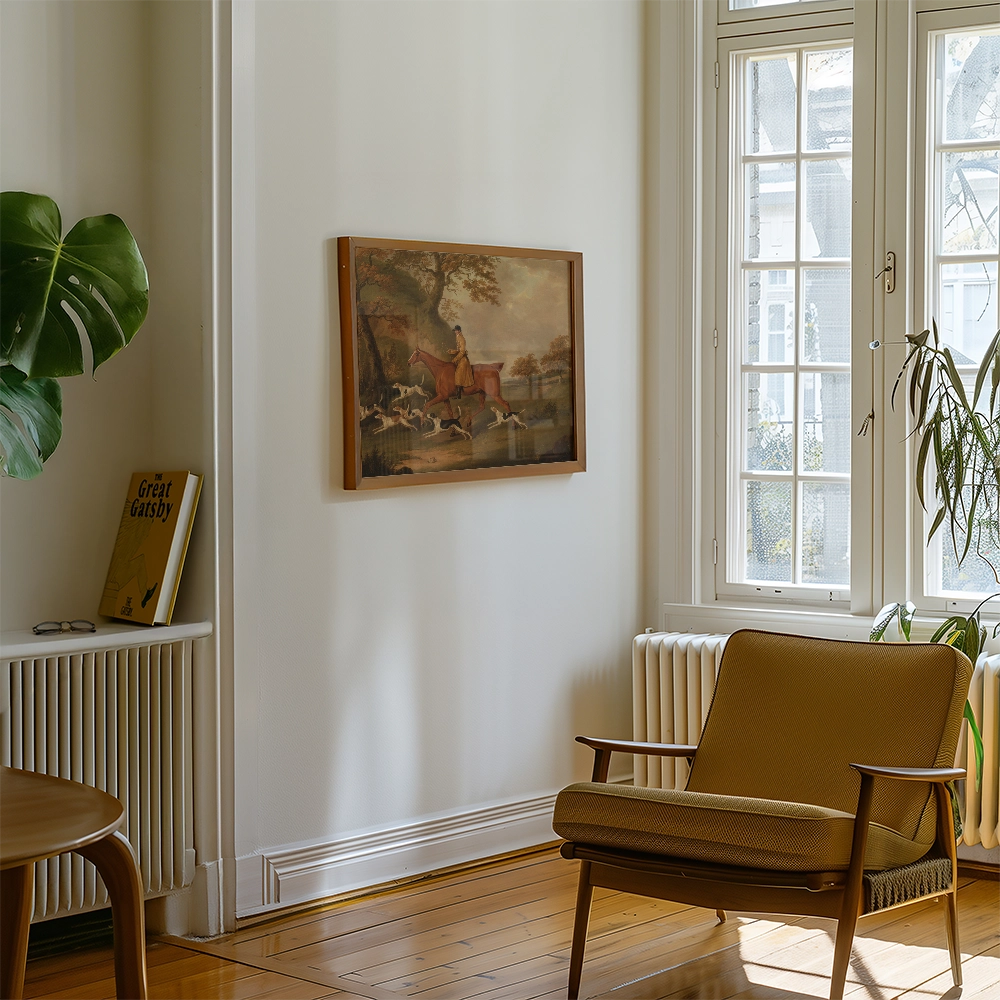 Painting of a horse and rider in a landscape, framed and displayed on a wall in a modern living room with a green plant and a mid-century armchair.