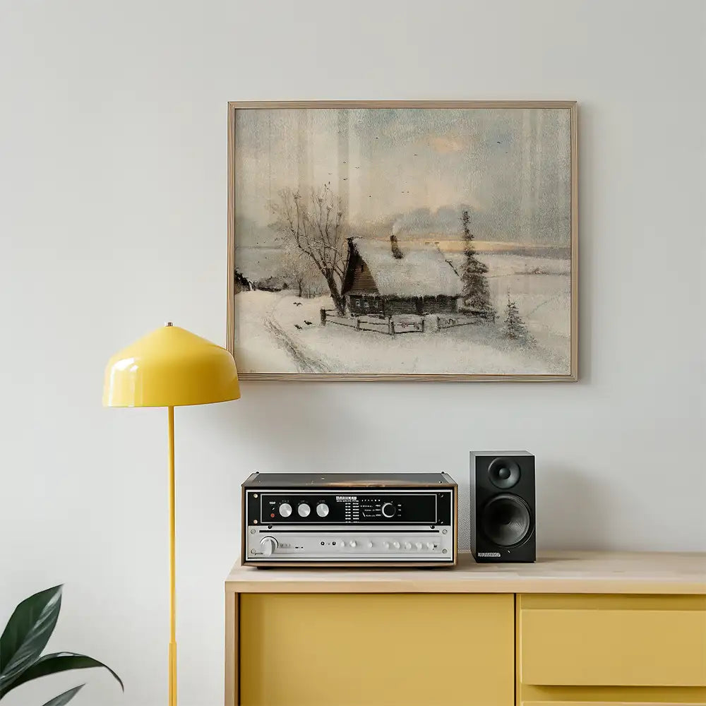 Framed winter landscape painting featuring a snow-covered cabin, with a yellow lamp and audio equipment in a modern living space.