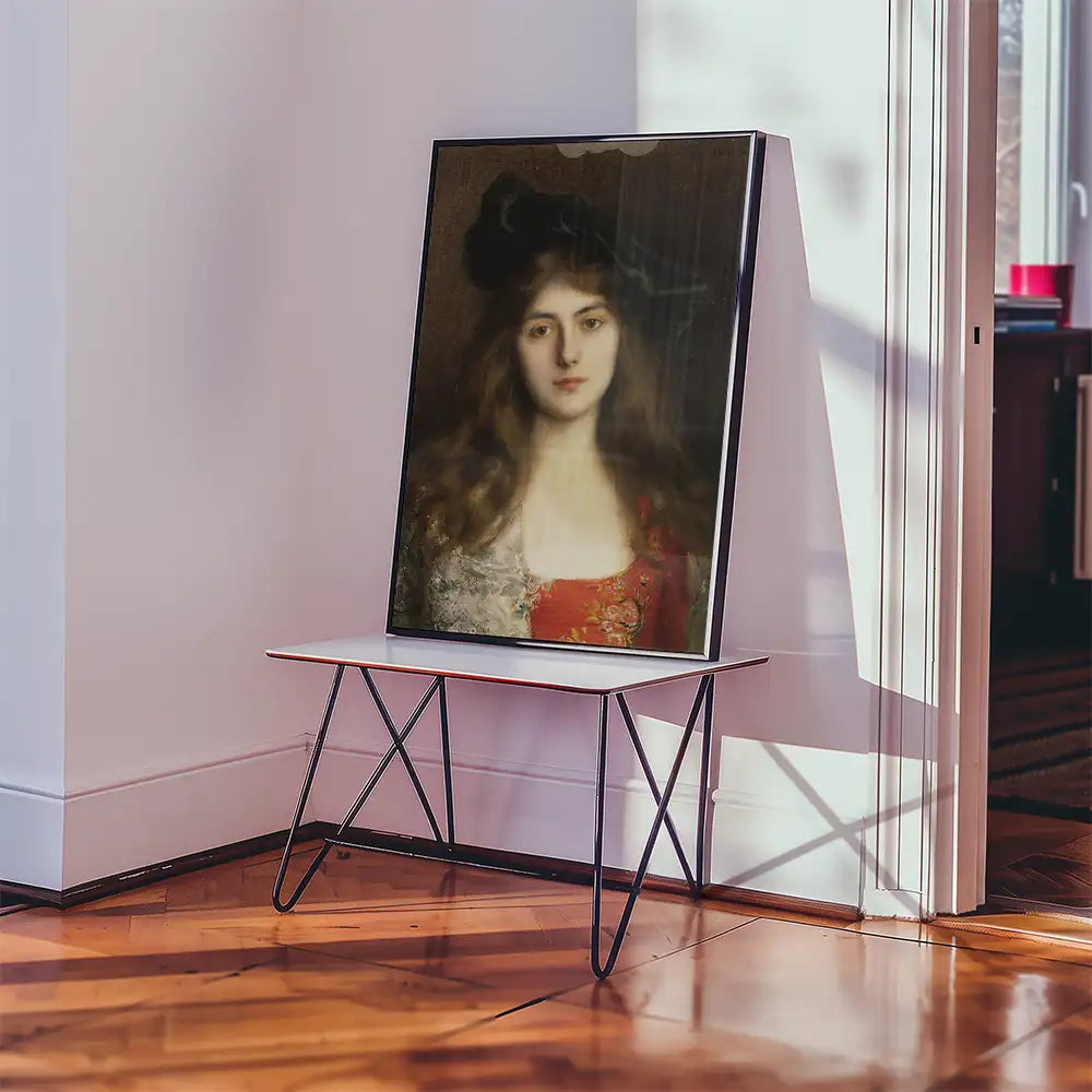 Painting of a woman with long hair and a red dress displayed on a modern table in a bright room.