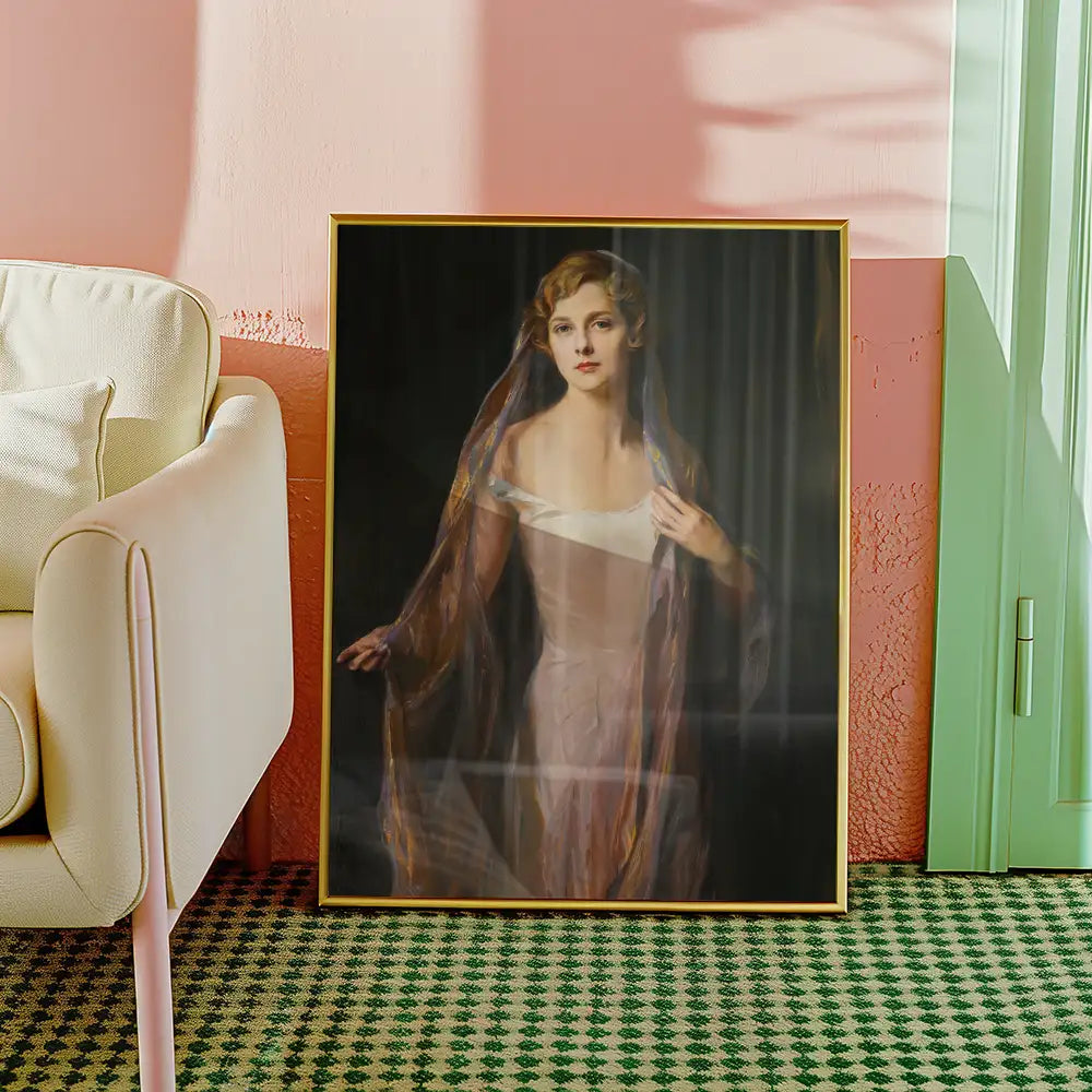Painting of a woman in a sheer gown with a flowing scarf, framed and leaning against a wall near a beige sofa and green door in a stylish interior setting.