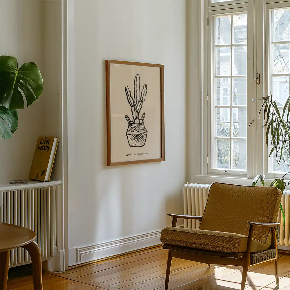 Modern wall art print featuring a minimalist cactus illustration in a pot, framed in wood, enhancing contemporary interior decor.