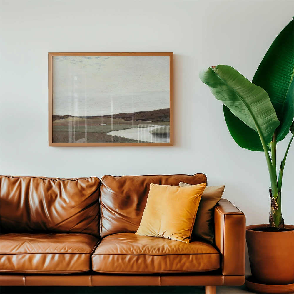 A serene landscape painting framed above a stylish brown leather sofa with a yellow pillow, complemented by a large green plant in a pot.
