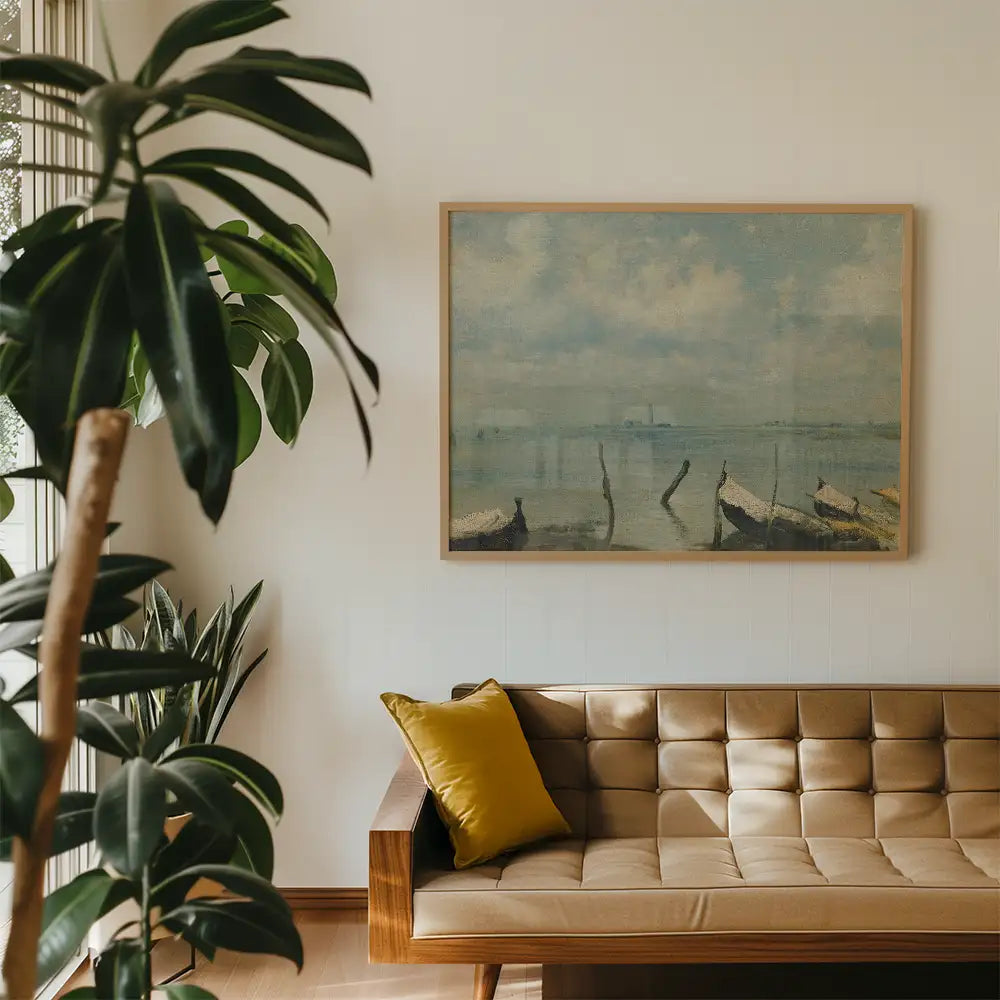 Framed painting of boats on a serene lake with a cloudy sky, displayed on a wall above a stylish brown couch with a yellow pillow, surrounded by indoor plants.