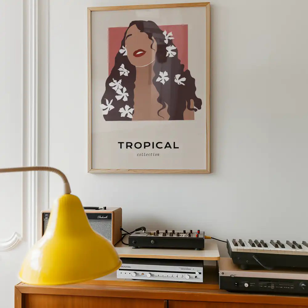 Modern tropical poster featuring a woman with flowers in her hair, framed and displayed against a minimalist interior setting.