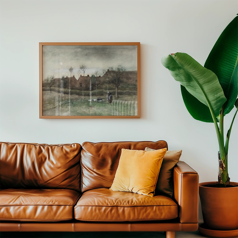 A framed painting of a rural landscape with trees and a figure, displayed above a brown leather sofa with decorative pillows and a large green plant.