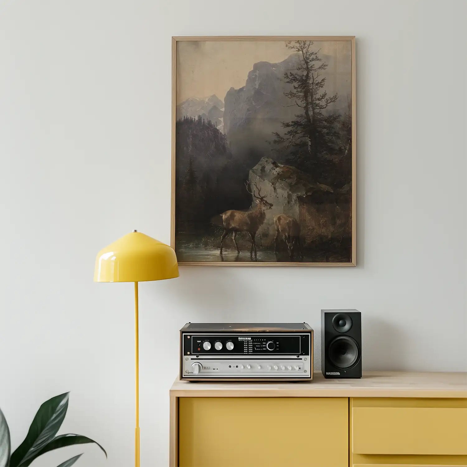 Landscape painting featuring two deer in a serene natural setting, framed and hung above a yellow floor lamp and a sleek audio system, with a minimalistic wooden cabinet.