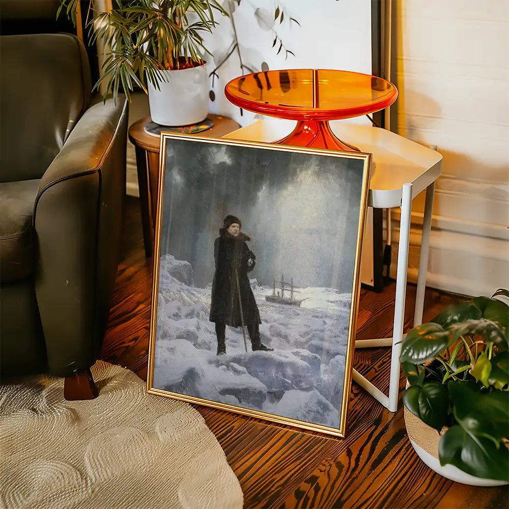 Framed painting of a figure standing in a snowy landscape with a ship in the background, placed next to a modern chair and side table.