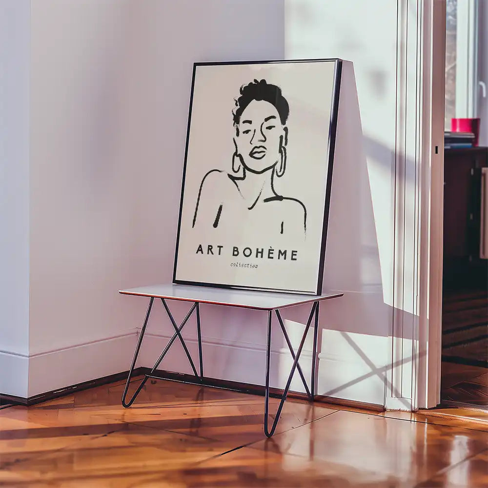 Modern minimalist poster featuring a stylized woman with the text "ART BOHÈME" displayed in an interior setting with a sleek table and warm wooden flooring.