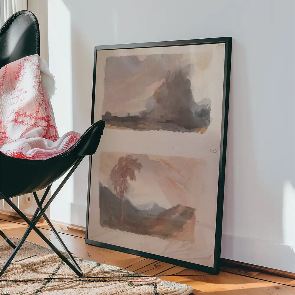 Framed abstract watercolor painting leaning against a wall with a black chair and patterned rug in a bright interior setting.