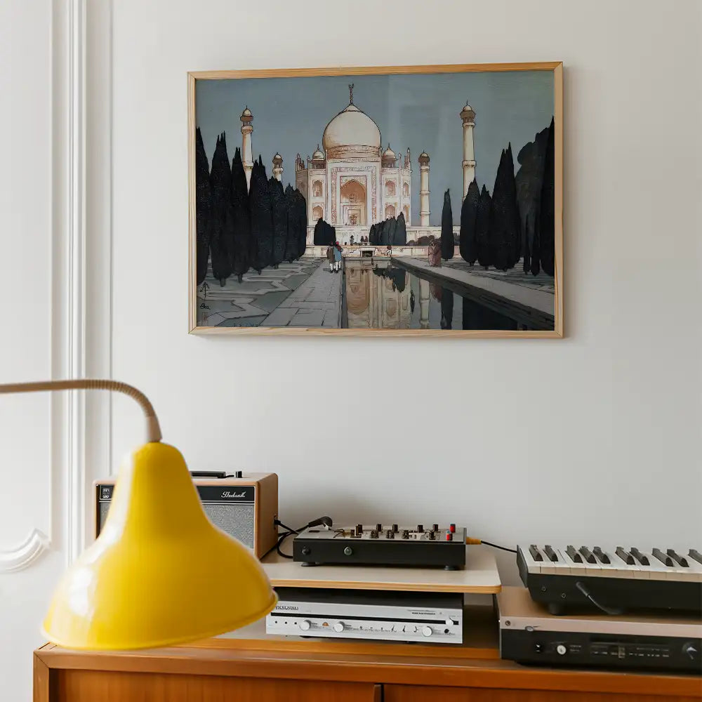 Painting of the Taj Mahal framed on a wall above a wooden cabinet with a yellow lamp and vintage audio equipment.