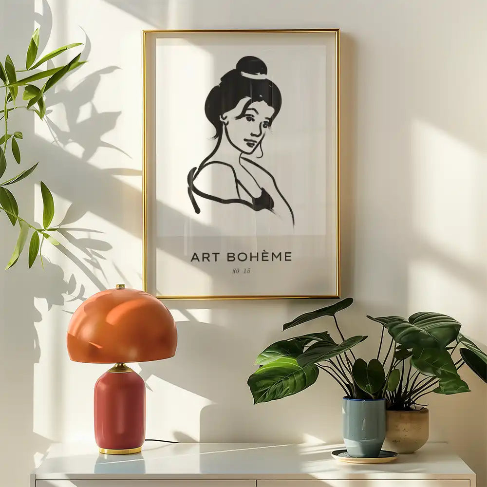 Modern poster of a famous painting featuring a woman with a bun, framed in gold, and accompanied by a stylish lamp and houseplants in a sunlit interior.