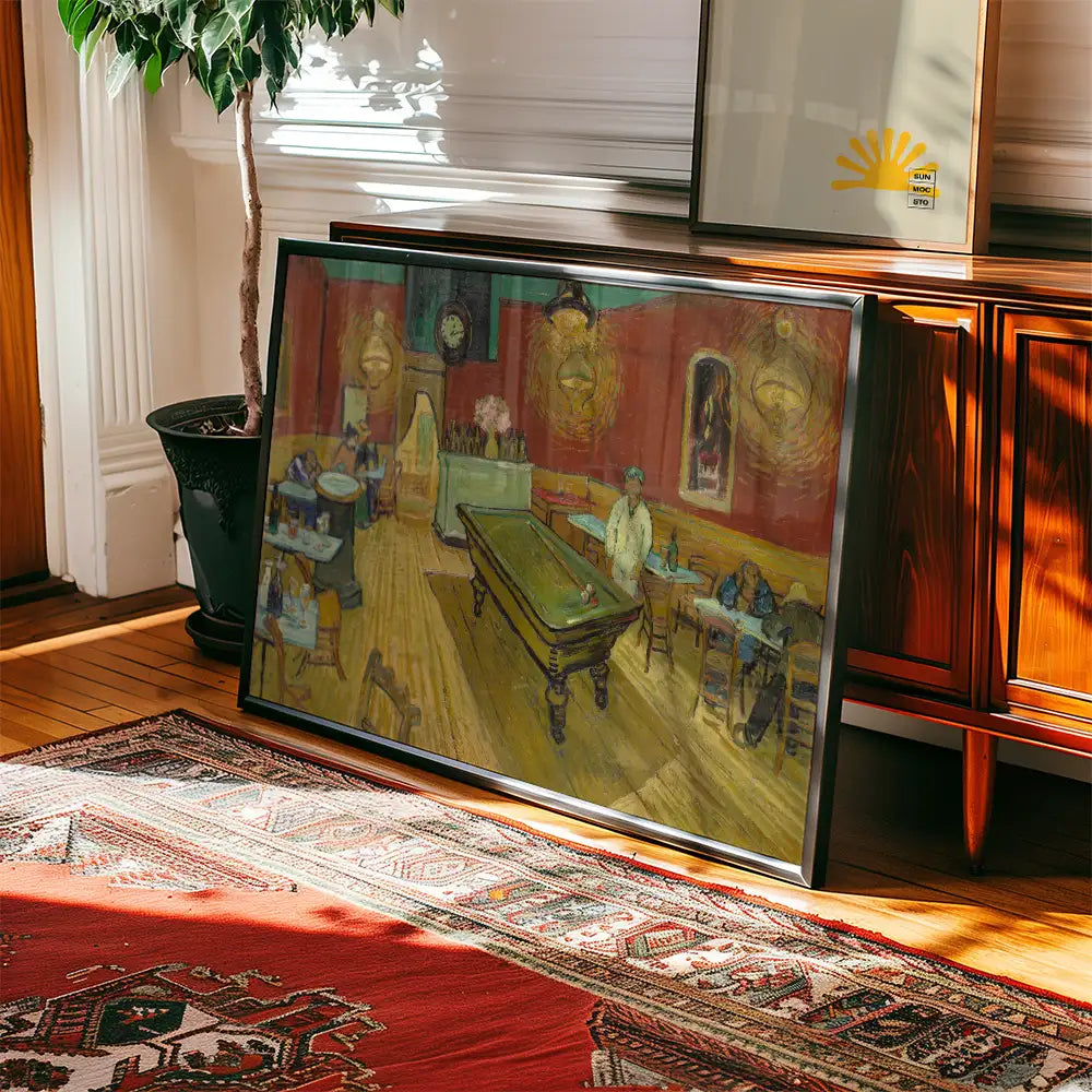 Framed painting of a lively tavern scene featuring a billiard table and patrons, displayed on a wooden floor beside a decorative rug and a plant.