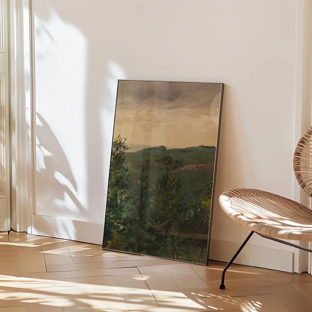 Framed landscape painting leaning against a wall next to a woven chair, with natural sunlight casting shadows on the floor.