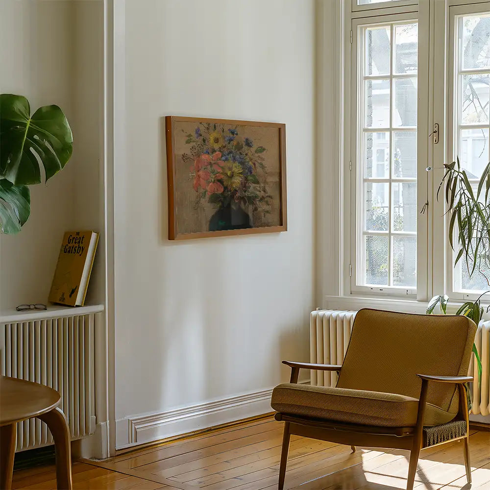 Framed painting of a floral arrangement hanging on a wall in a cozy living room setting