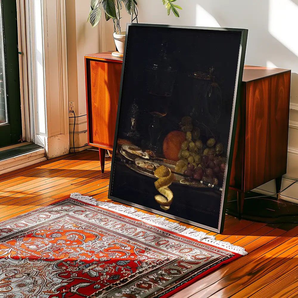 A framed still life painting featuring various fruits and a glass on a wooden table, displayed in a bright room with hardwood floors and a decorative rug.