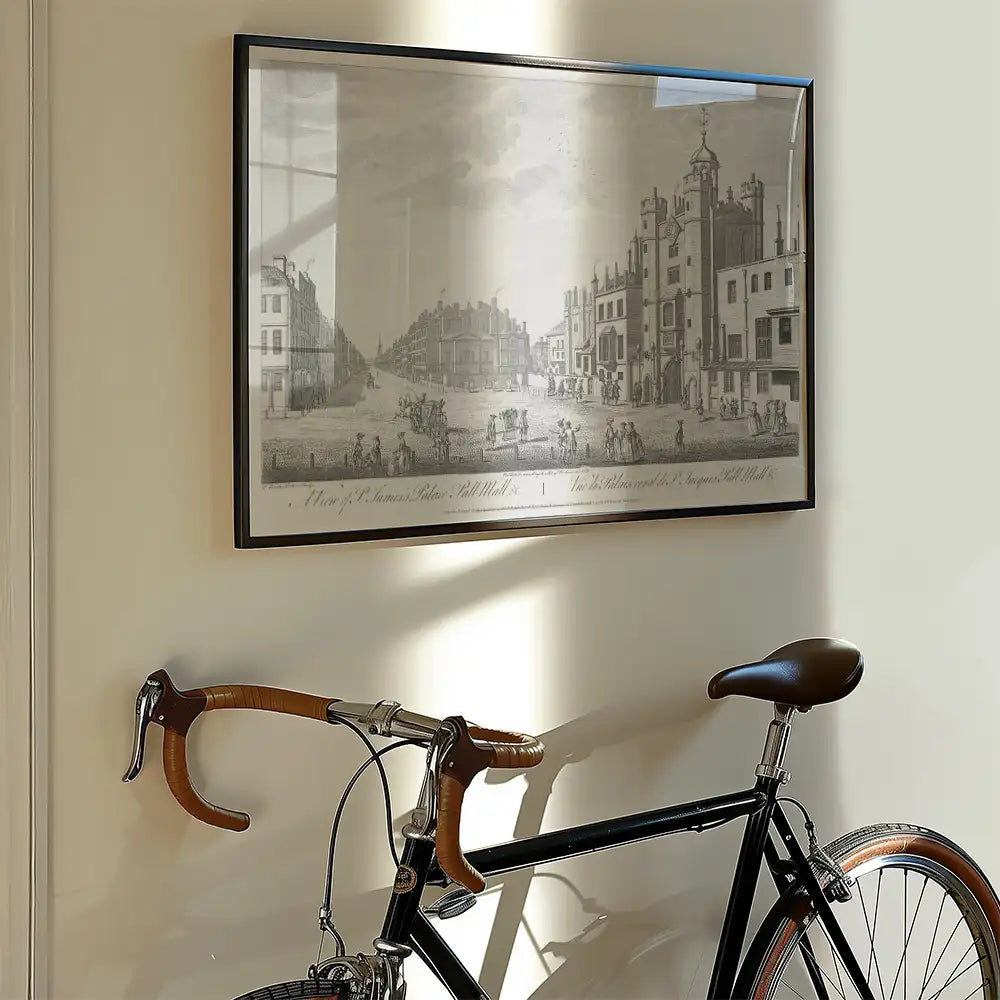 Black bicycle with brown leather details leaning against the wall, next to a vintage framed black and white artwork depicting a street scene.