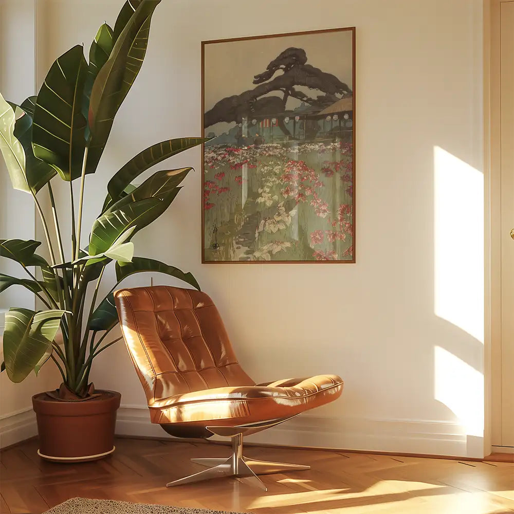 Painting of a serene landscape with flowers and trees, framed on a wall beside a stylish brown chair and a large green plant.