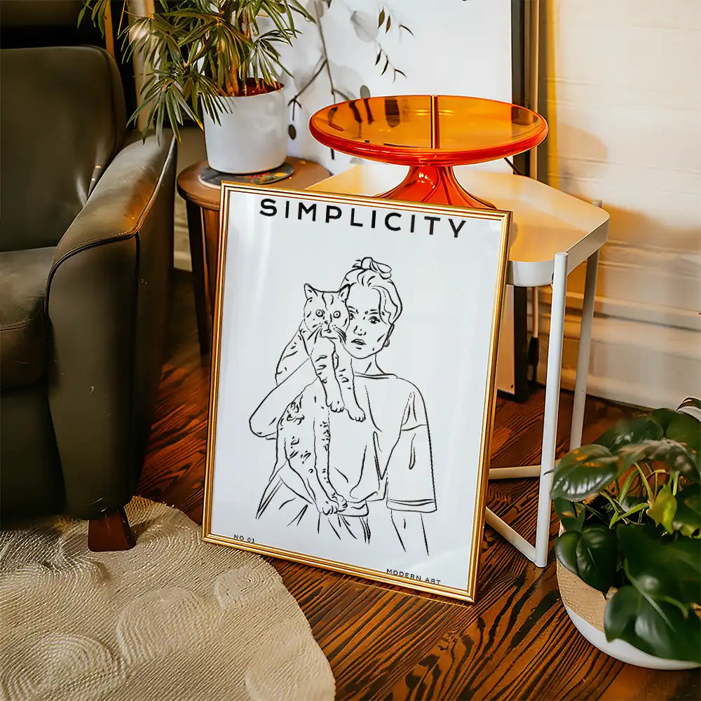 Modern art poster featuring a minimalist line drawing of a woman holding a cat, framed in gold, with the word "SIMPLICITY" at the top, ideal for trendy home decor.