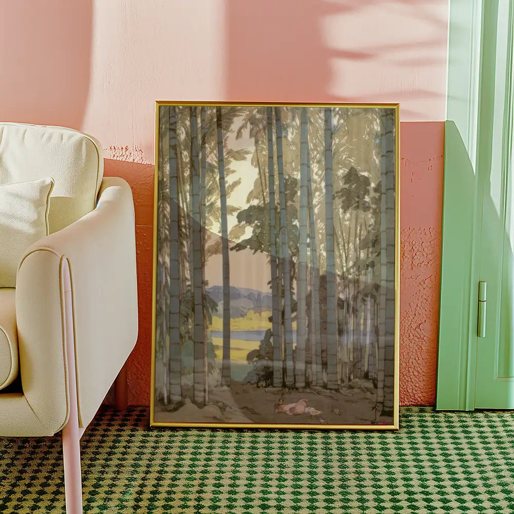 Framed painting of a serene forest landscape with trees and a distant lake, placed next to a light-colored armchair in a stylish room.