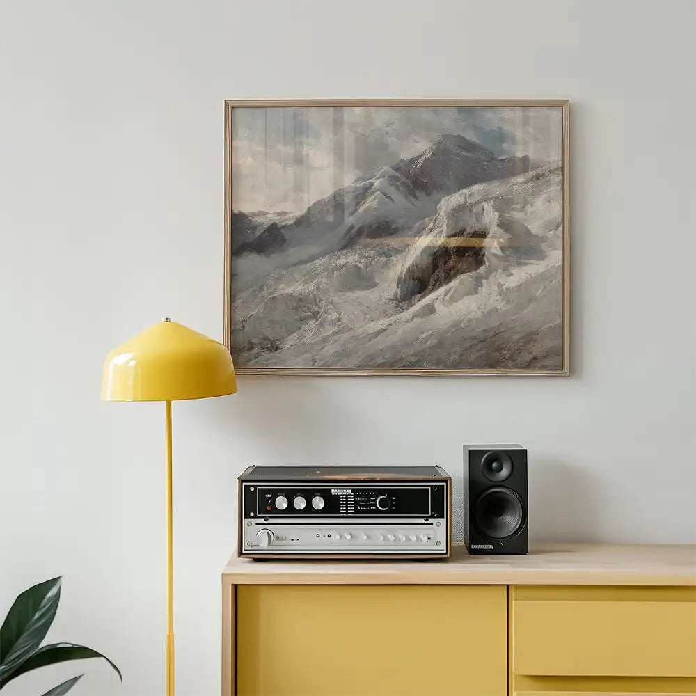 A framed painting of a mountain landscape hung on a wall above a wooden console with a yellow lamp and a speaker.