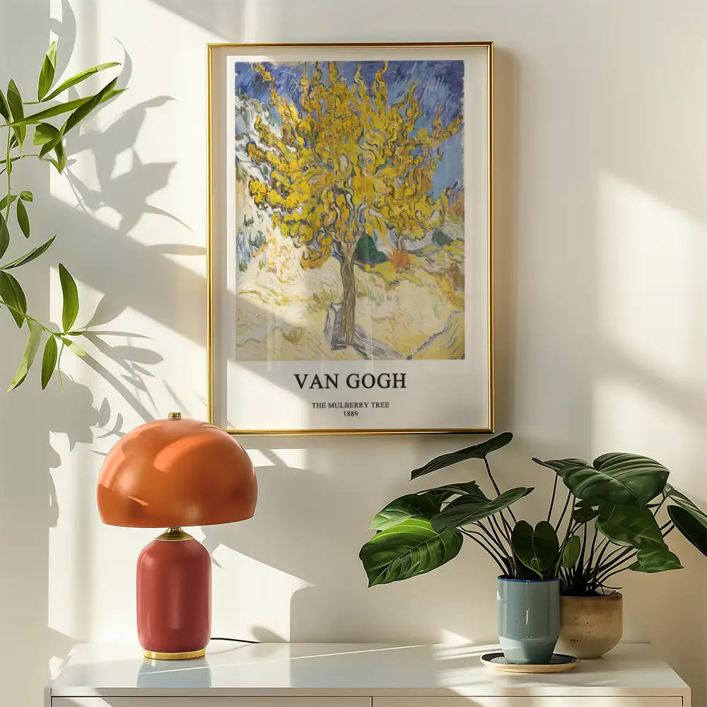 Framed poster of Van Gogh's "The Mulberry Tree" (1889) displayed on a light wall, accompanied by a modern lamp and potted plants.