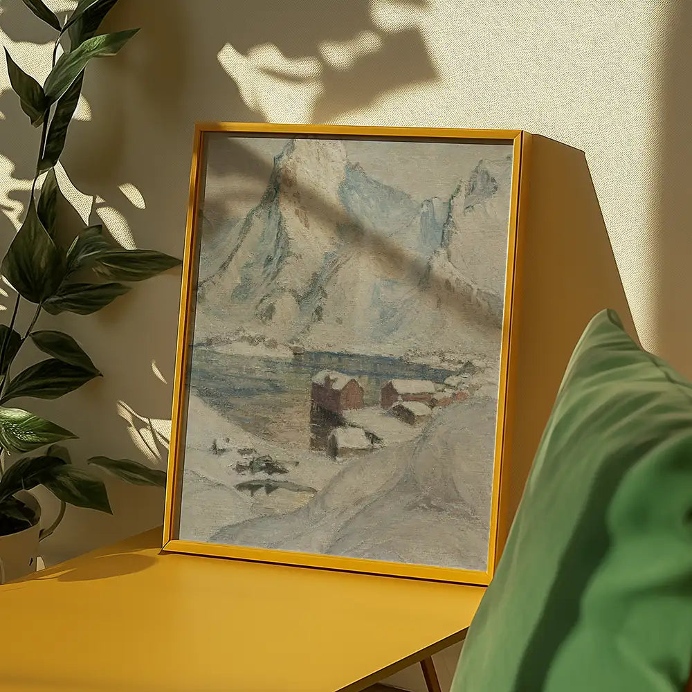 Framed painting of a snowy landscape with mountains, featuring a serene river and houses, displayed on a yellow table near green plants.