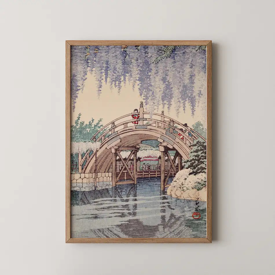 Framed painting of a wooden bridge over water with people and wisteria in a serene landscape setting.