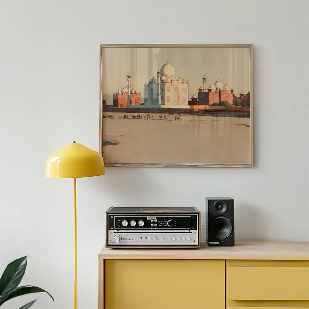Framed painting of a historical building, possibly the Taj Mahal, displayed on a wall above a wooden cabinet with a yellow lamp and vintage audio equipment.