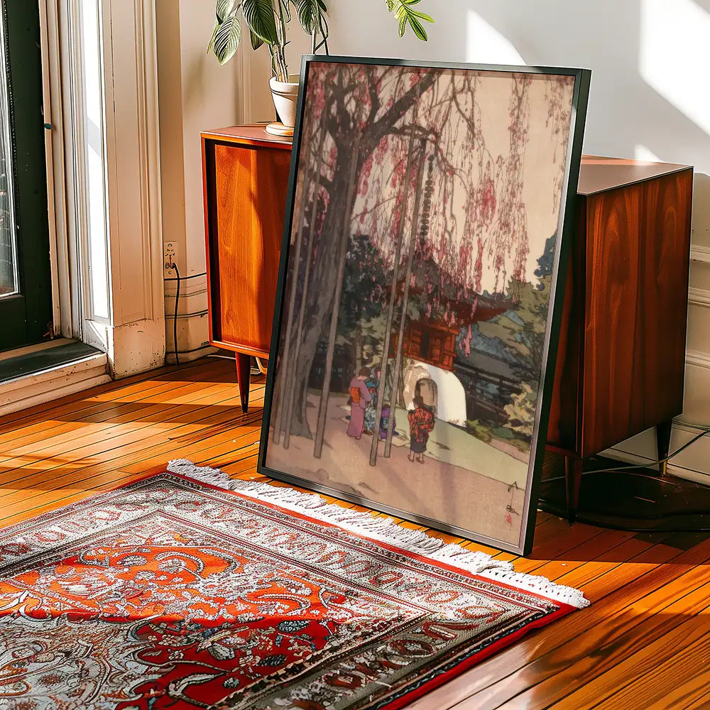 Framed painting of a serene landscape featuring cherry blossom trees and traditional figures, displayed in a stylish interior setting with wooden flooring and a decorative rug.