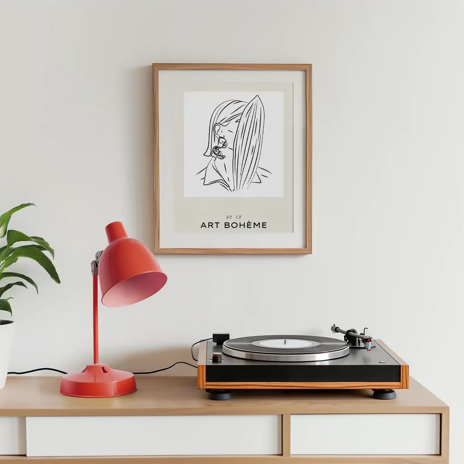 Modern reprint of a famous painting featuring a minimalist line drawing of a woman with a surfboard, framed in a stylish wood frame, displayed in a contemporary living space with a red lamp and a turntable.