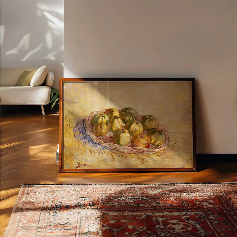 Framed painting of a basket of green and yellow apples on a wooden floor near a vintage rug.