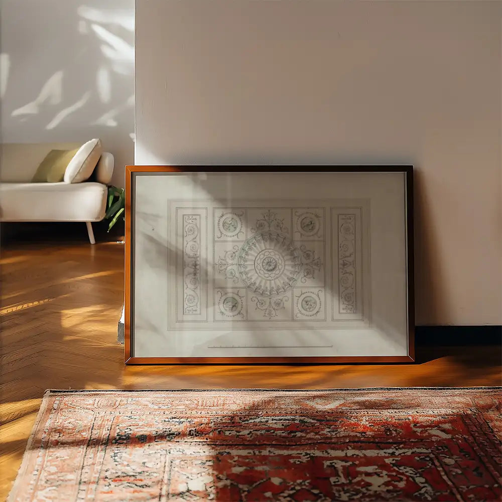 Framed wall art featuring intricate floral design, leaning against a wall in a stylish room with wooden flooring and a patterned rug.