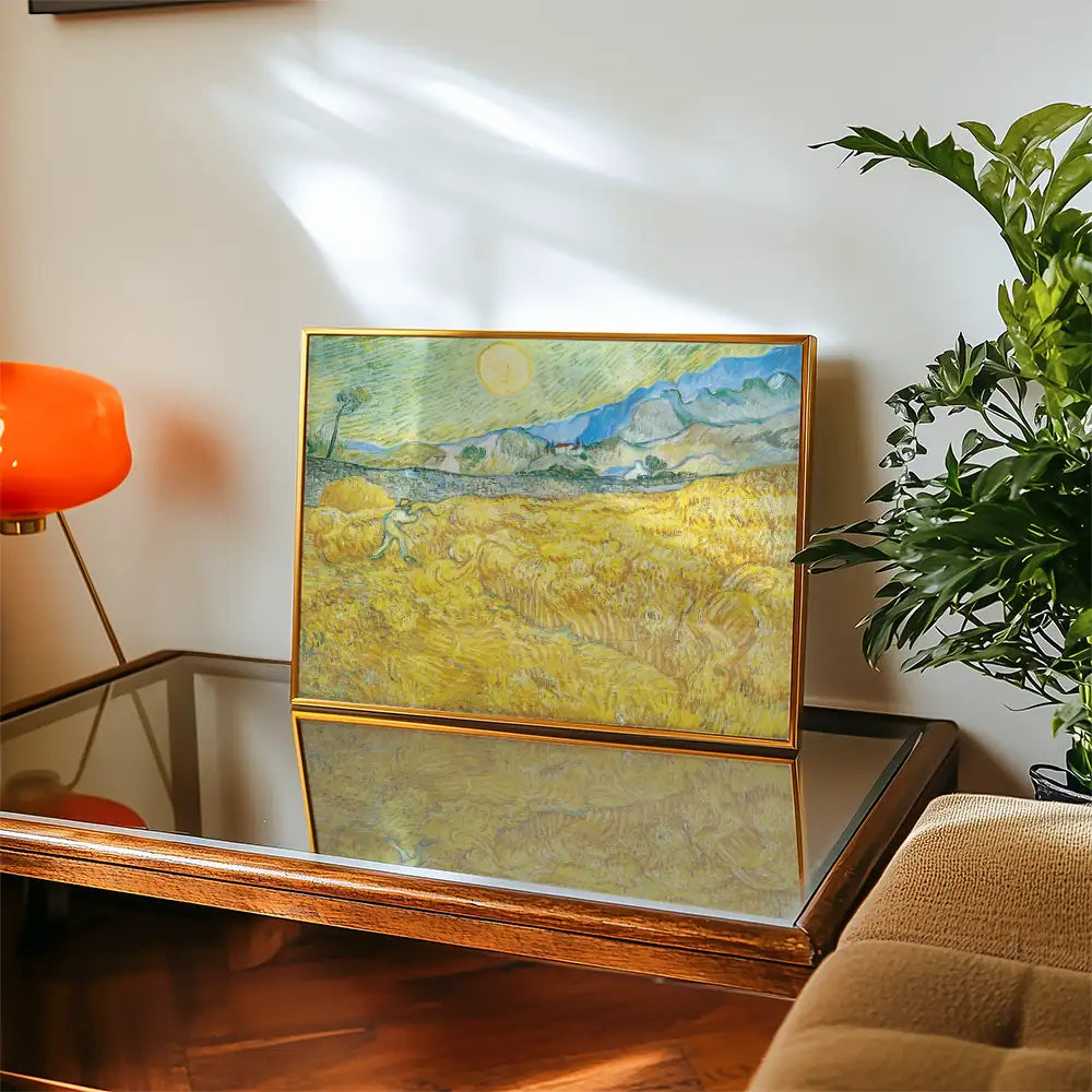 Painting of a sunlit landscape with golden fields and mountains, displayed on a wooden coffee table next to a plant and a modern orange lamp.