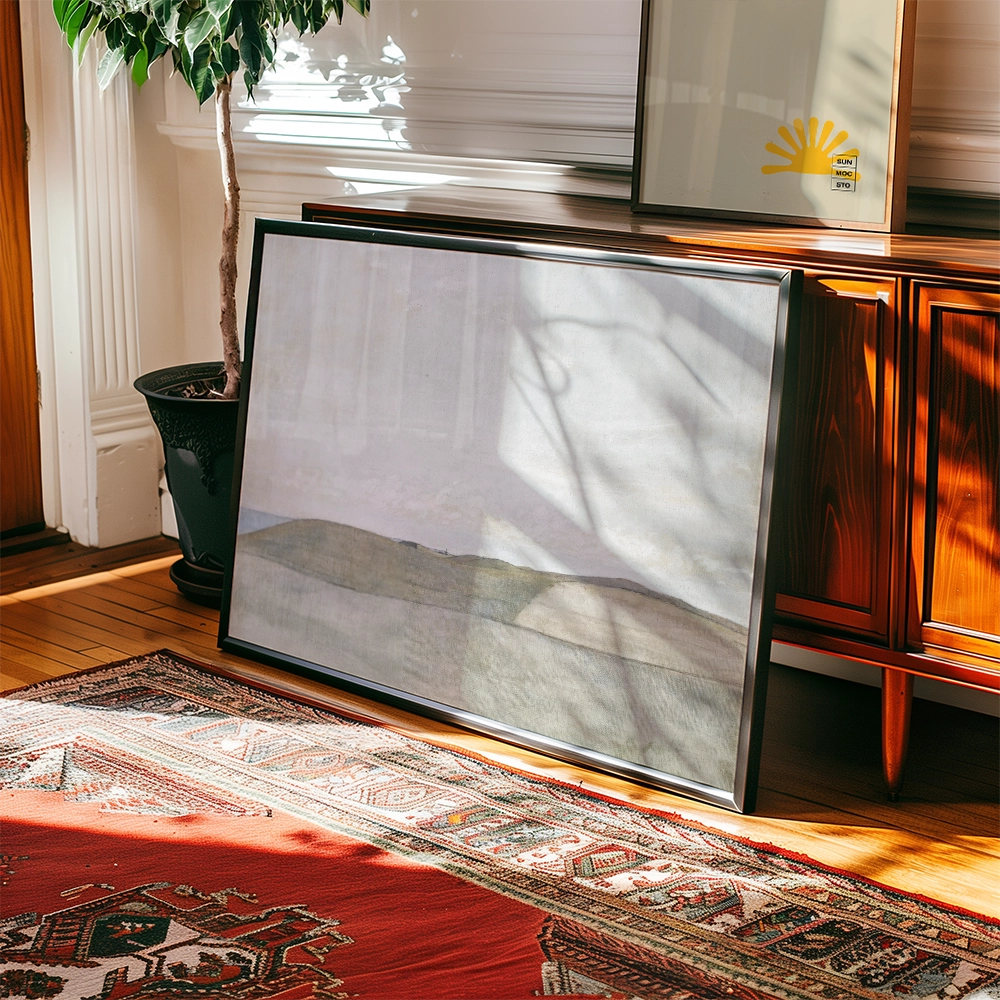 A framed painting leaning against a wooden dresser with a decorative rug and a plant in a bright, sunlit room.