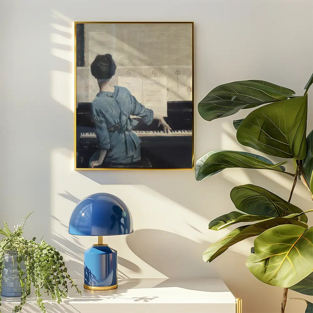 Painting of a woman in a blue dress playing a piano, framed in gold, with a blue lamp and green plant in a bright interior setting.