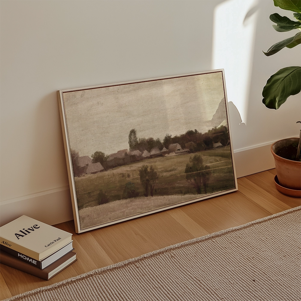 Framed painting depicting a serene landscape with rolling hills and distant trees, leaning against a wall next to books and a potted plant.