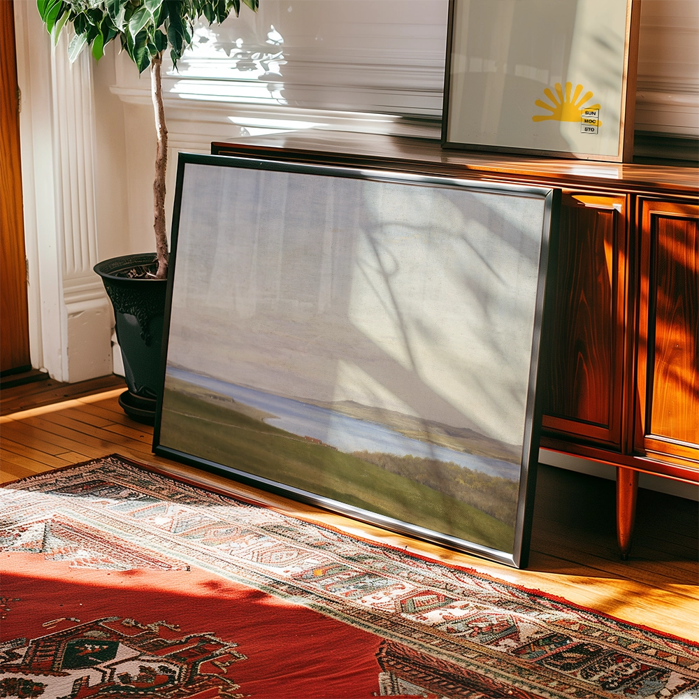 Framed landscape painting resting against a wooden cabinet in a sunlit room, with a decorative rug and indoor plant visible.
