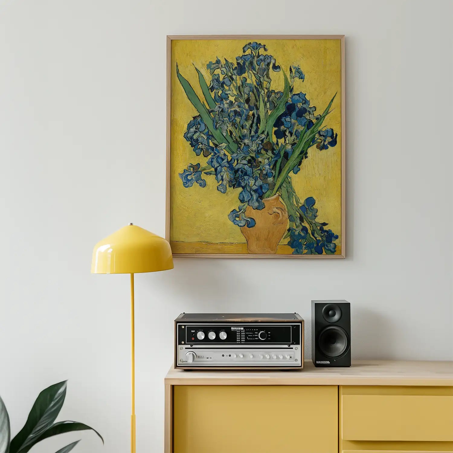 A vibrant painting of blue irises in a terracotta vase against a yellow background, displayed in a modern room with a yellow lamp and vintage audio equipment.