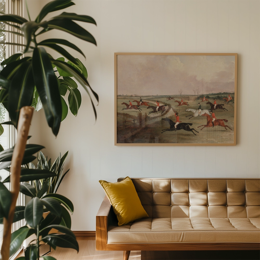 Painting of horse riders in action, framed and displayed above a modern sofa in a stylish interior with plants.