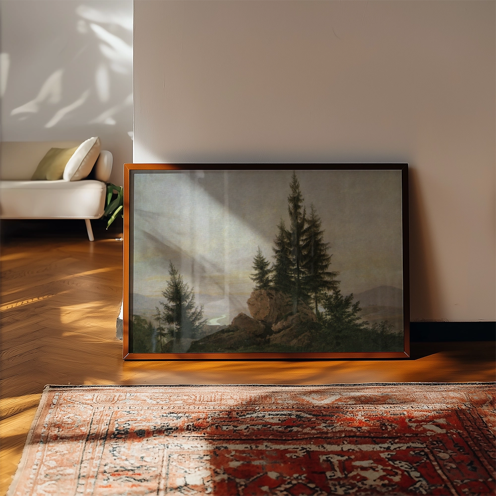 Framed landscape painting featuring tall trees and a rocky outcrop, displayed in a bright living room setting with wooden flooring and a decorative rug.