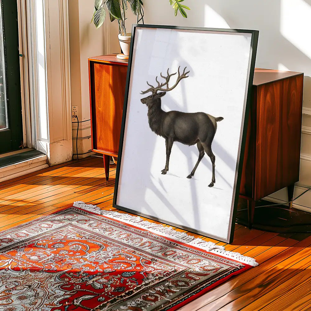 Framed artwork featuring a black deer standing on a white background, displayed in a stylish living room setting with wooden floors and a decorative rug.