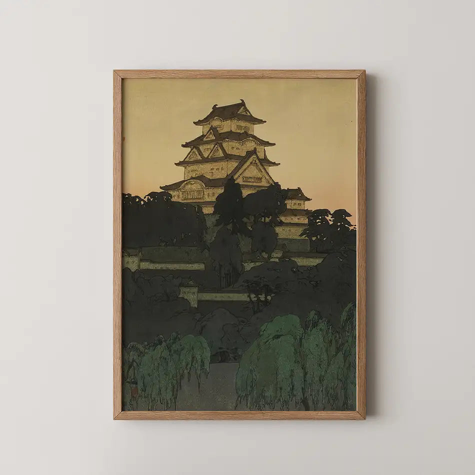 Framed painting of a traditional Japanese castle at sunset, surrounded by trees.