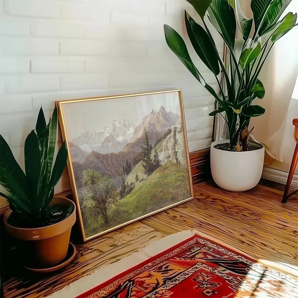 Framed mountain landscape painting leaning against a wall with indoor plants and a decorative rug.