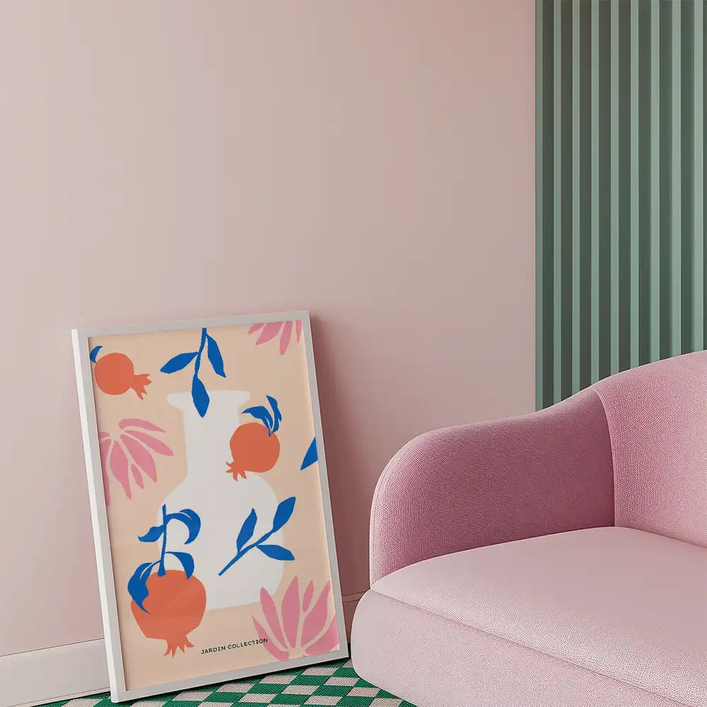 Modern art poster featuring vibrant pomegranates and leaves, framed elegantly, complementing a stylish interior with pastel tones.